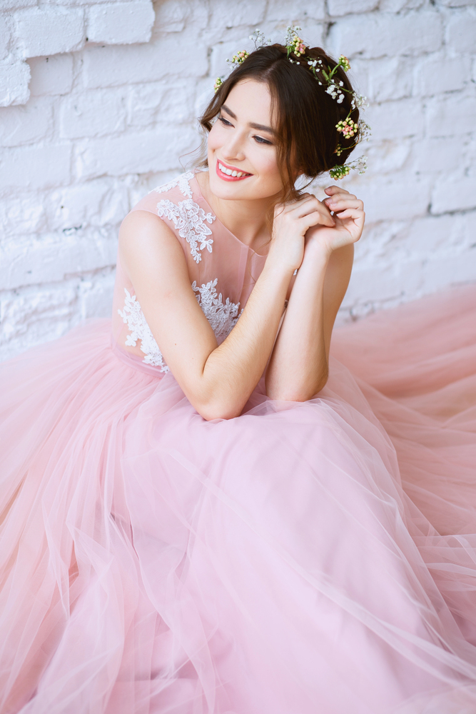 belle femme dans une belle robe de mariée rose pale