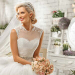Mariée souriante en robe élégante tenant son bouquet, instant paisible avant la cérémonie