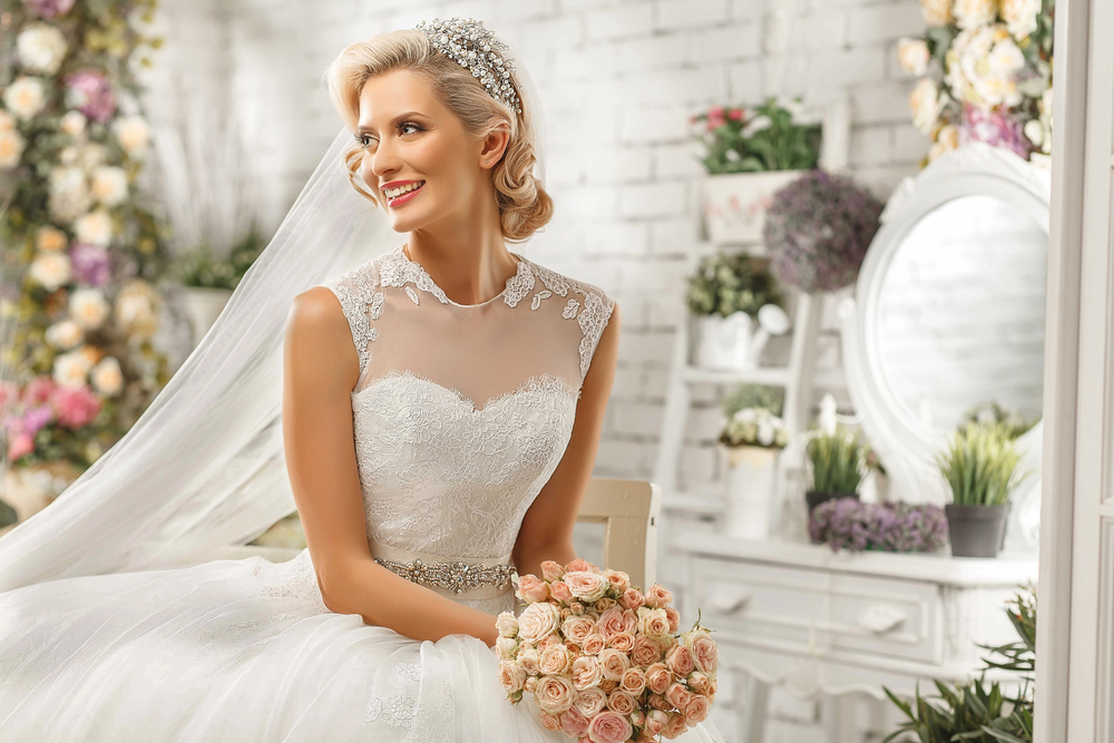 Mariée souriante en robe élégante tenant son bouquet, instant paisible avant la cérémonie