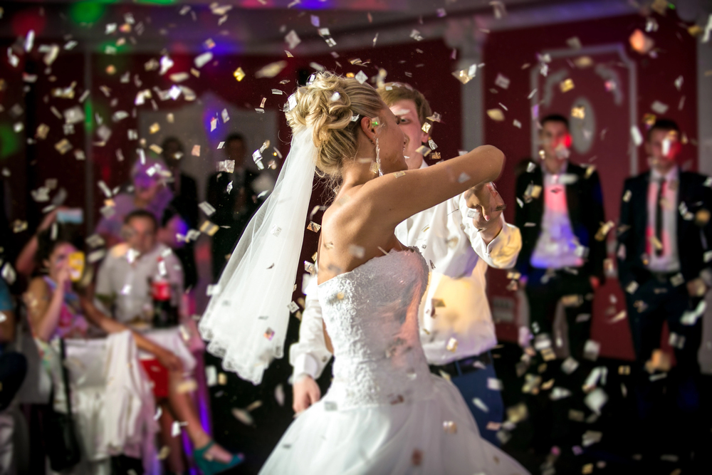 Mariée en robe bustier dansant sous des confettis, ambiance festive de soirée de mariage