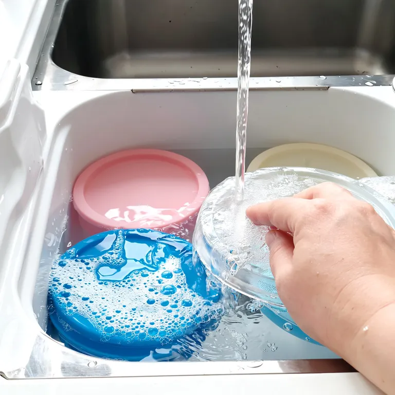 Nettoyage facile de couvercles extensibles en silicone sous l’eau chaude avec éponge douce