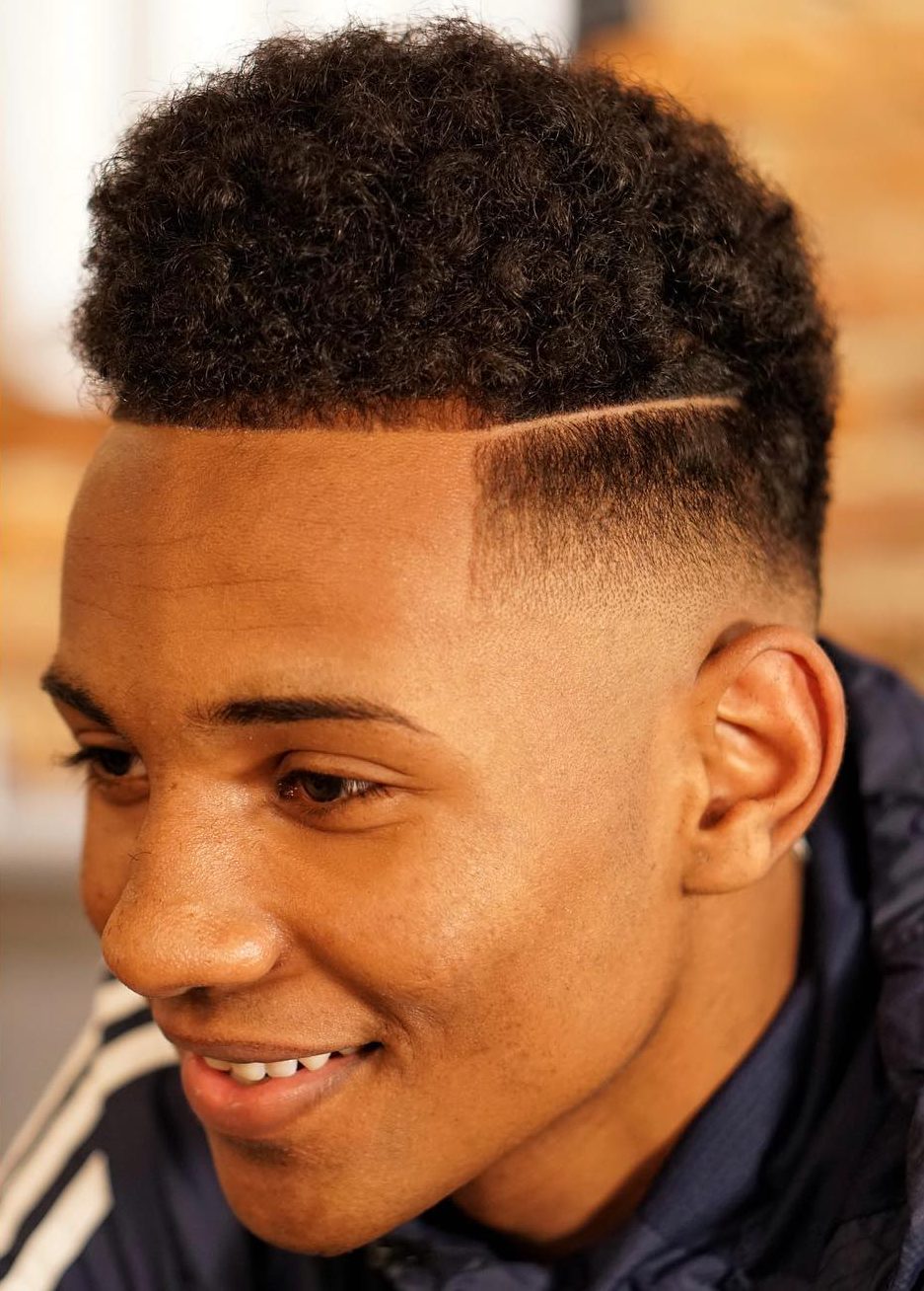 Low fade with hard part and curls on top