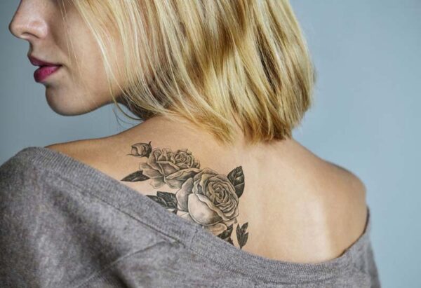 Tatouage féminin coloré dans le dos pour blonde de 40 ans