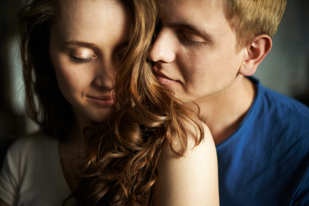 Couple enlacé dans un moment de tendresse, symbole d’une connexion émotionnelle et physique forte