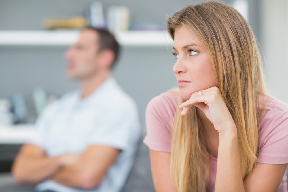 Femme pensive en couple, symbole de doute et d’ambiguïté dans la relation