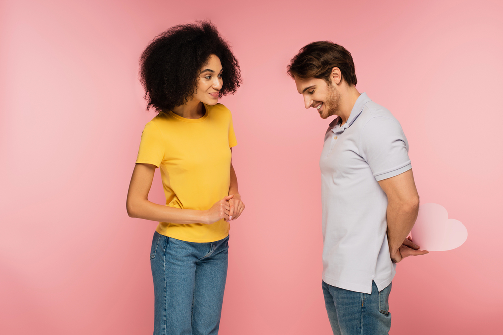 Homme timide cachant un cœur derrière son dos, tentative discrète de montrer ses sentiments