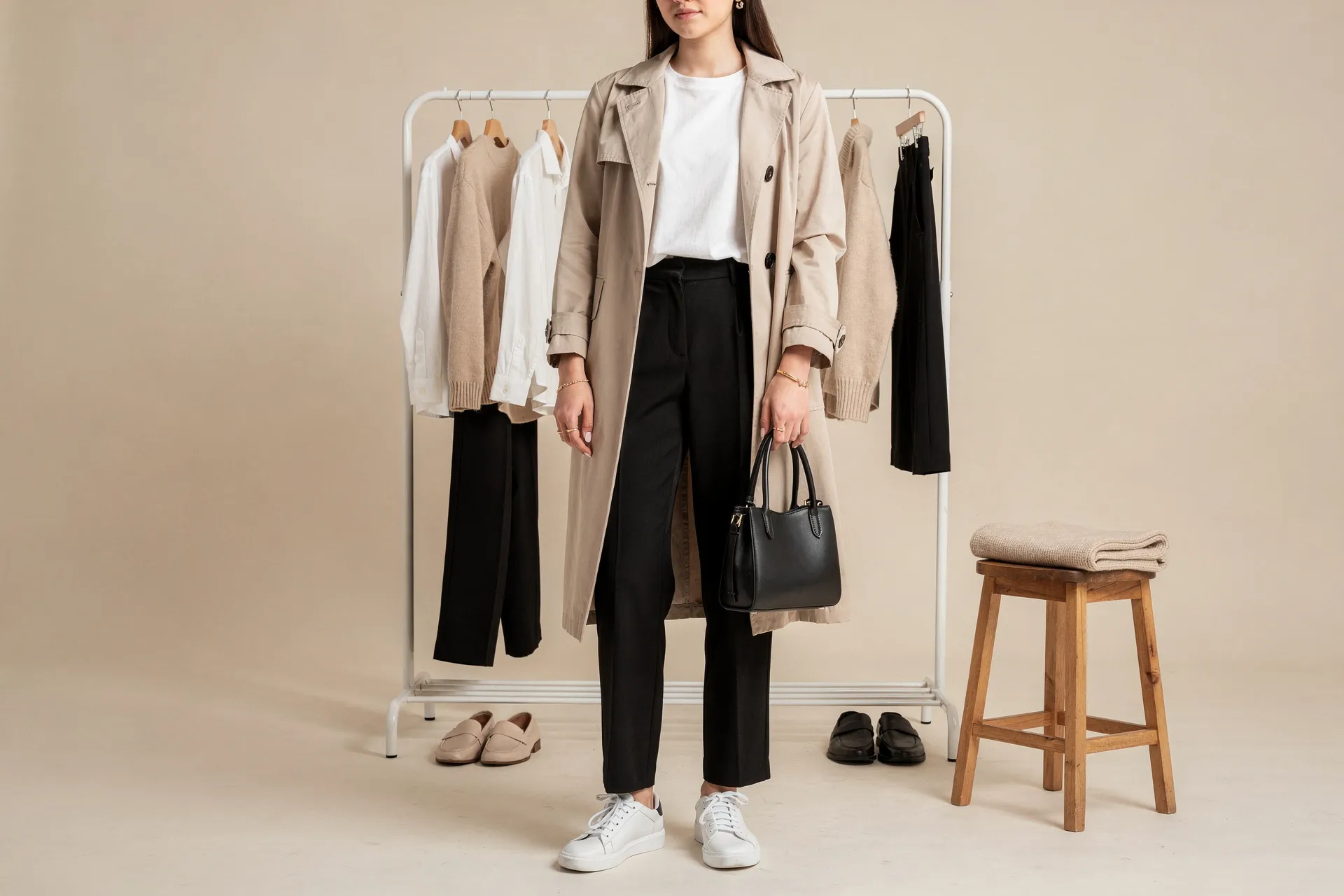 Femme devant son dressing minimaliste composé de pièces intemporelles et neutres, présentant une garde-robe pensée pour réduire les achats inutiles.