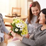 joyeux petits-enfants offrent bouquet de fleurs à grand-mère pour fête