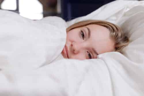 jeune femme couchée dans linge de lit blanc