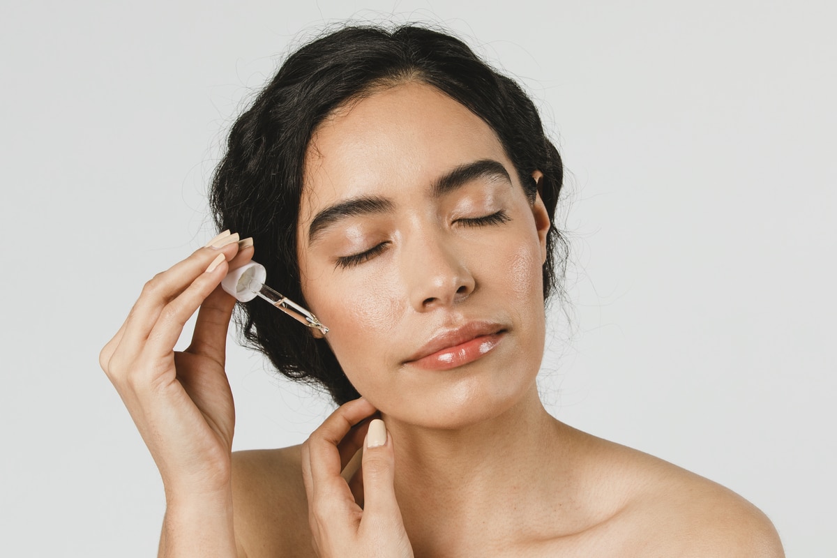 young woman applying serum on her face 2021 09 02 06 01 56 utc 1 - Les 10 conseils ultimes pour un soin du visage efficace et anti-âge