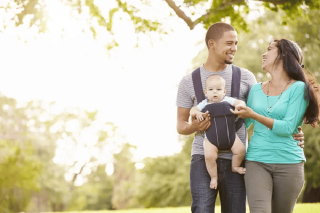 couple avec un bebe dans un porte bebe