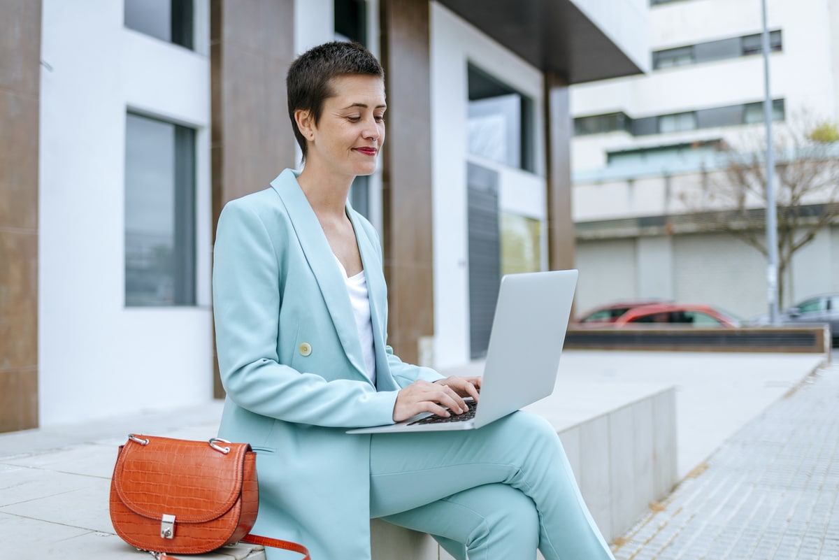 woman in suit jacket using laptop outdoors 2022 03 08 01 24 06 utc1 - Le top des vêtements élégants et tendances pour cet été !