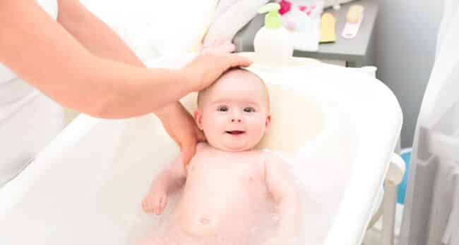 adorable baby girl in bath with mother looking up 2021 08 28 14 28 28 utc 1 650x348 - Comment rendre l'heure du bain plus amusante pour votre bébé ?