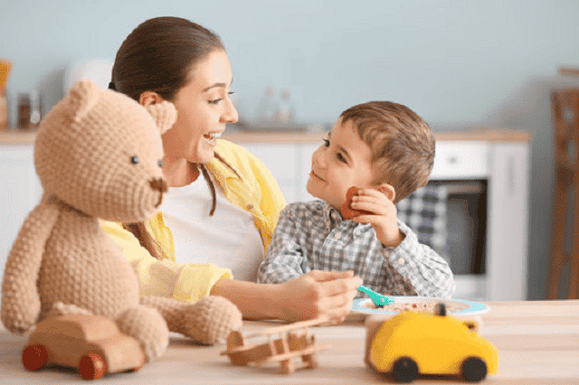 jeune fille nounou joue avec un mignon petit garçon