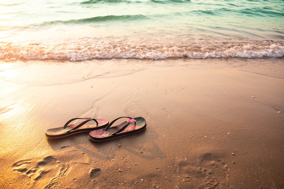 flip flops or sandals for woman on sand beach at c 2022 01 26 20 00 42 utc - Les incontournables vestimentaires pour des vacances tendances en septembre !