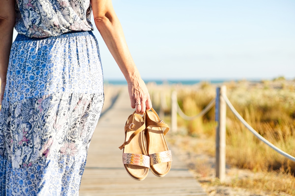 unrecognizable woman walking to the beach in sanda 2022 05 10 04 09 25 utc - Les incontournables vestimentaires pour des vacances tendances en septembre !