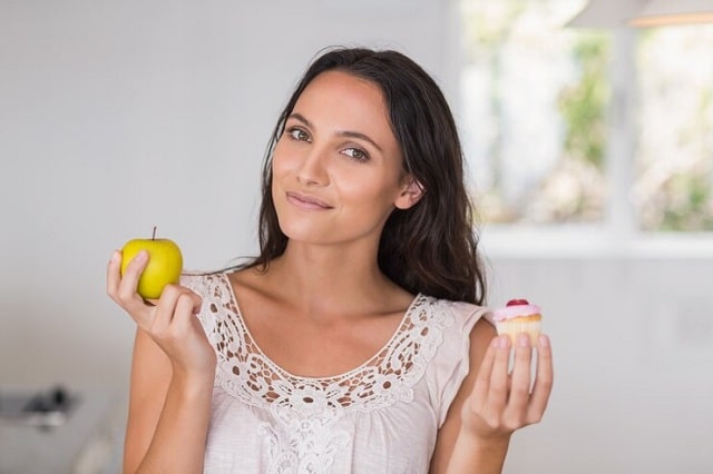 femme tenant dans ses mains une pomme et cupkace à la pomme