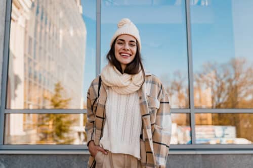 young smiling woman walking in street in winter 2021 12 09 08 34 41 utc 500x333 - Comment s'habiller pour un style chic et douillet ?