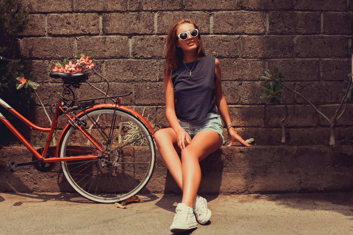 jeune femme avec vélo rétro et sneakers vintage