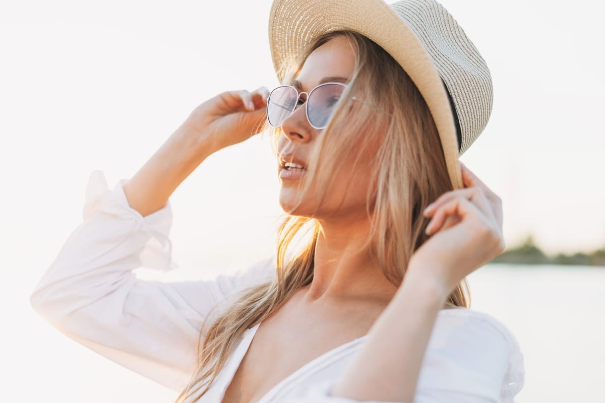 jeune femme tendance au chapeau de paille au coucher du soleil