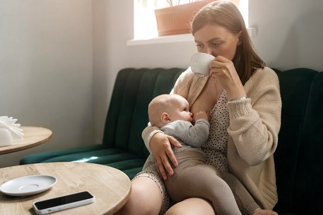  Mère buvant du café en allaitant son bébé