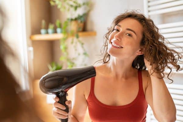 femme avec un sèche cheveux professionnel