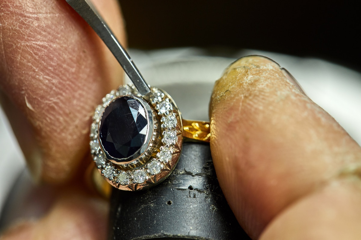 réparation de bijoux vintage. Le processus de fixation des pierres avec un fixateur. Fabrication de bijoux