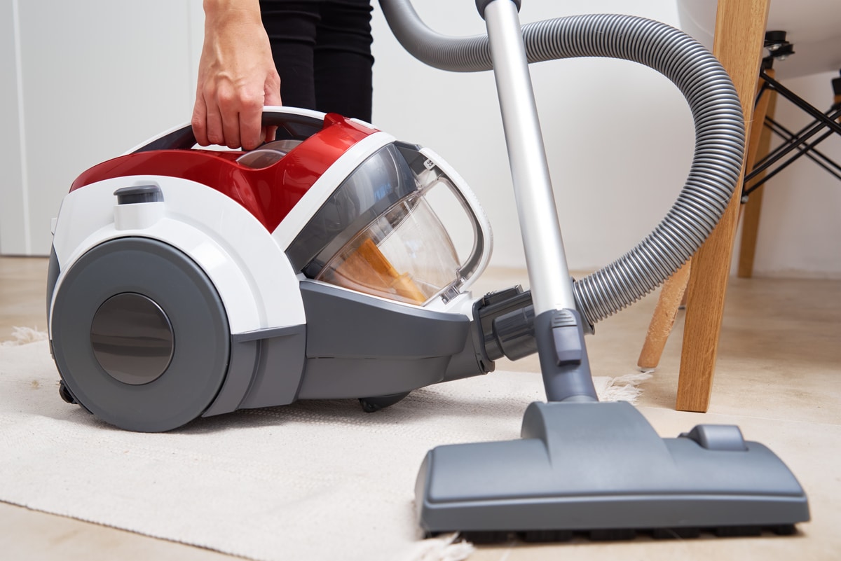 femme passant l'aspirateur sur le sol à la maison, aspirateur traineau sans fil