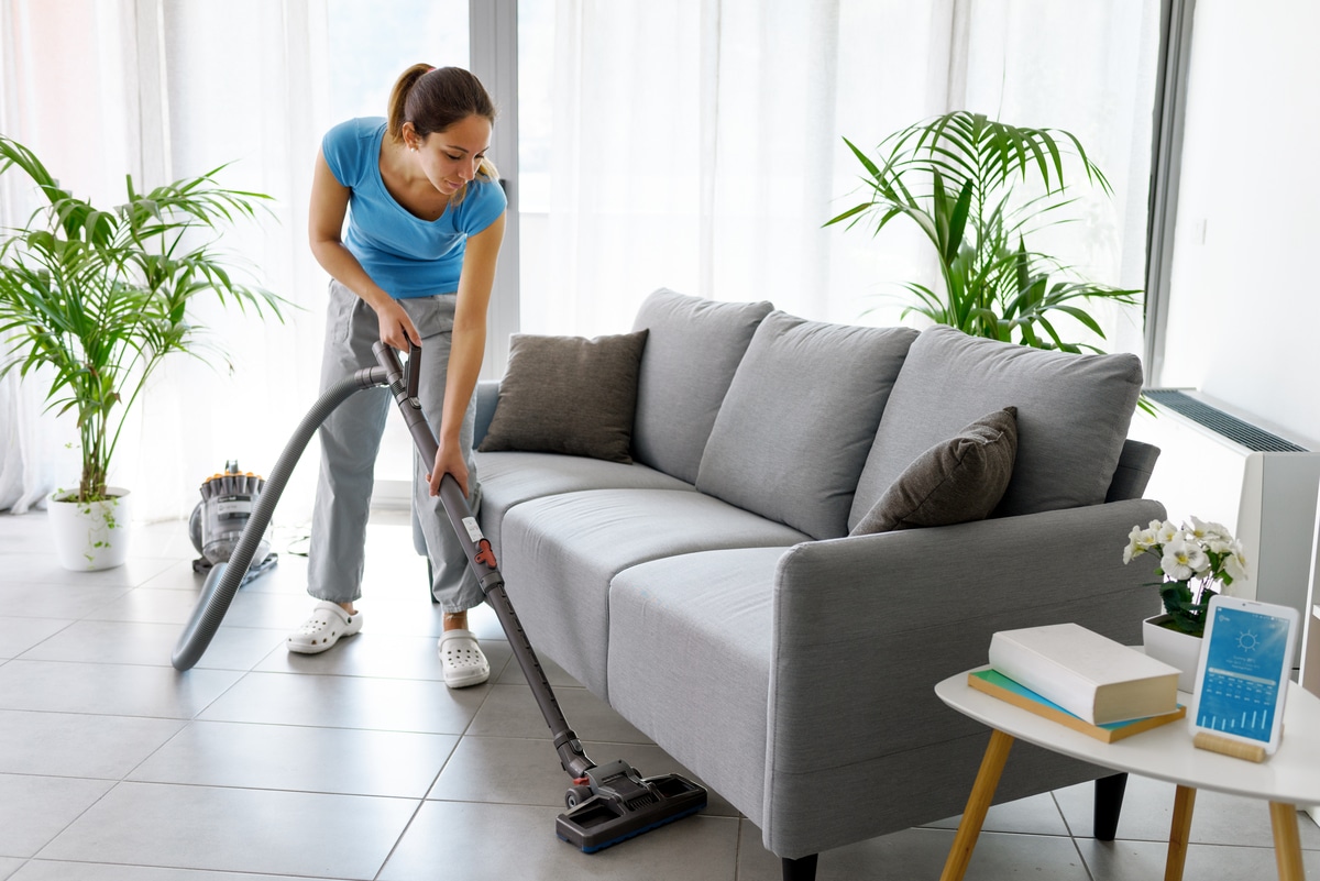 femme passant l'aspirateur sur le sol à la maison, aspirateur traineau sans fil