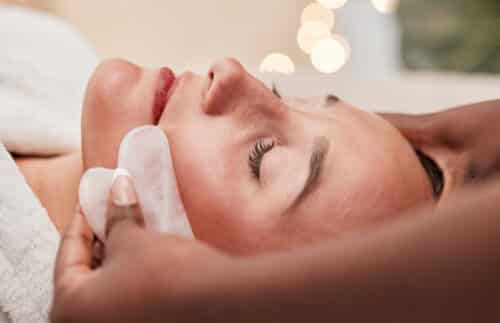 soins de la peau gua sha et femme se faisant masser le visage
