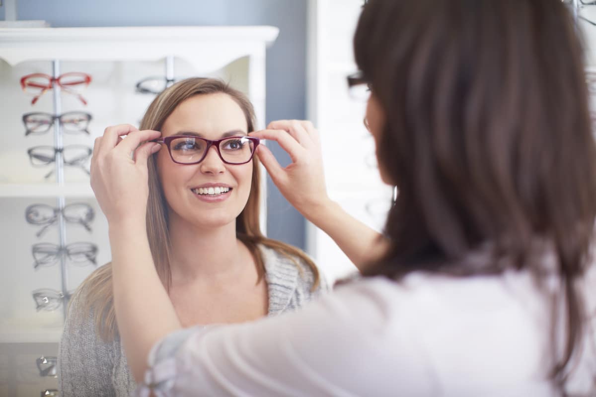 femme chez l'opticien essayant des lunettes lunettes de vue tendance