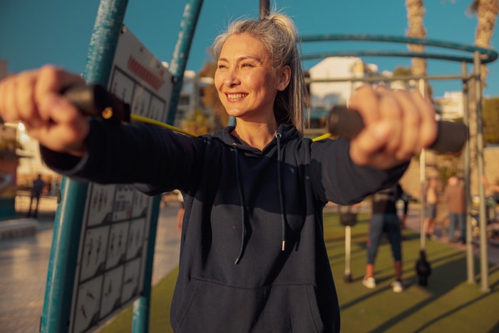 dame cinquantaine en vêtements de sport travaillant les bras à l'extérieur sport