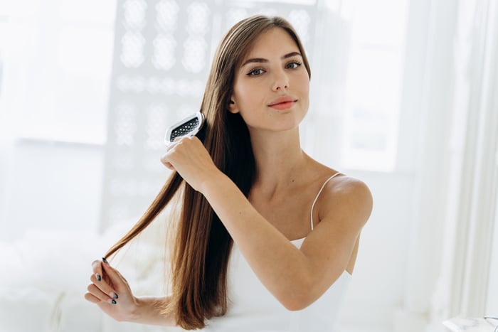 se brosser les cheveux. portrait de jeune femme se brossant les cheveux naturels droits avec un peigne.