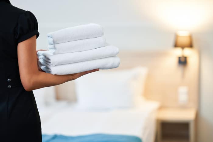femme de ménage avec serviettes propres chambre à coucher