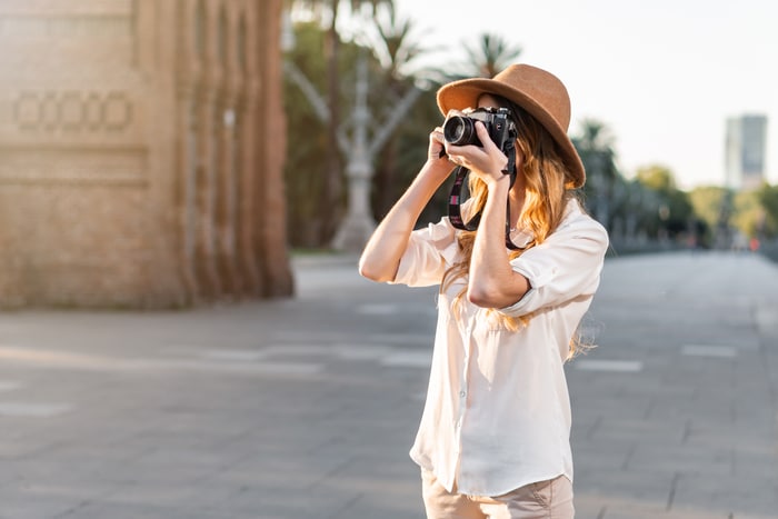 foyer peu profond d'une jeune femme touriste avec un chapeau fedora photographiant à barcelone, espagne