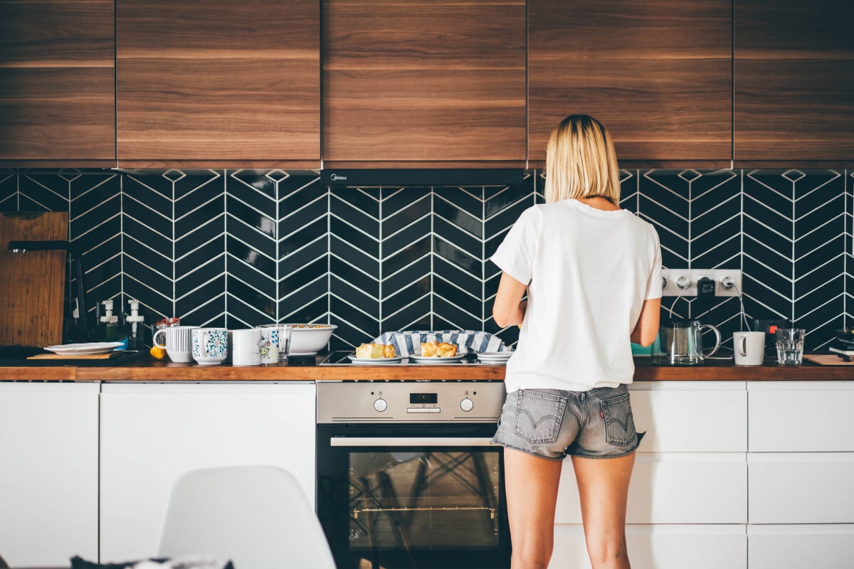 jeune femme se tient près de la cuisine moderne à la maison