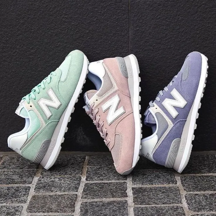 Sneakers New Balance 574 gris clair portées avec un jean et un haut casual