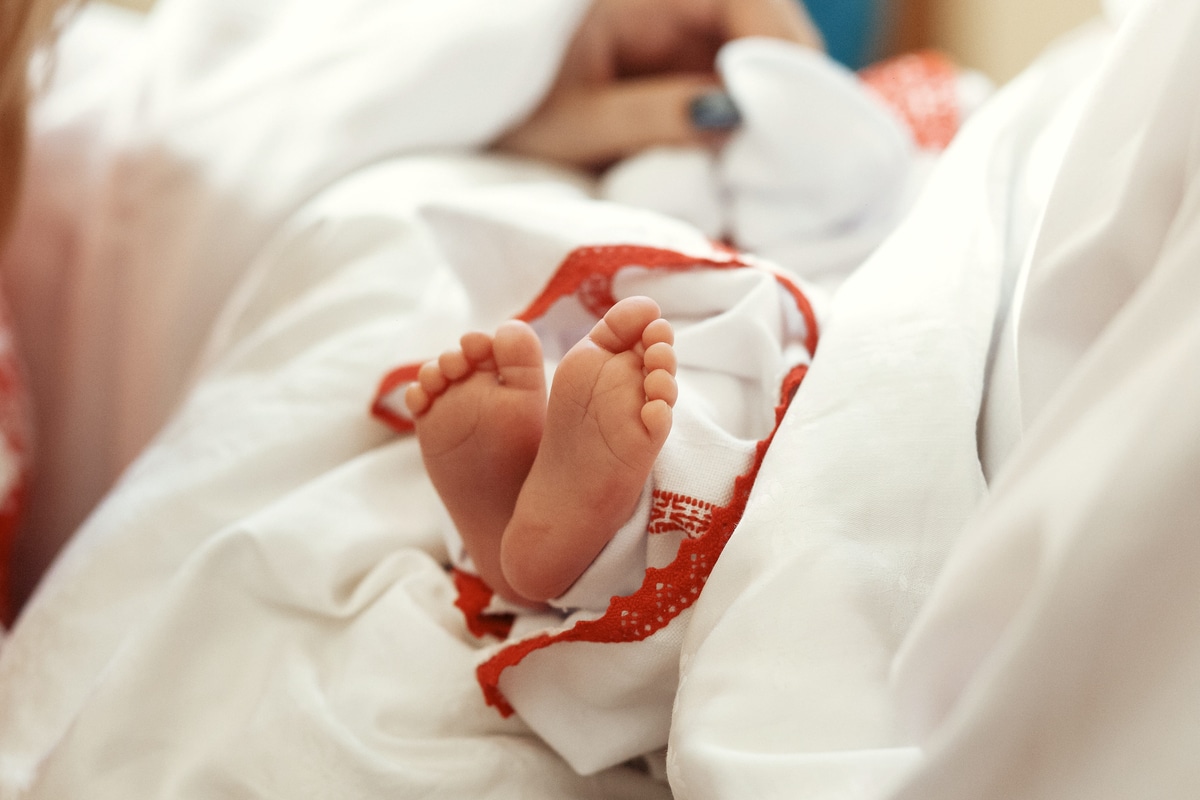 baptême bébé. mignons petits pieds d'une fille au baptême à l'église