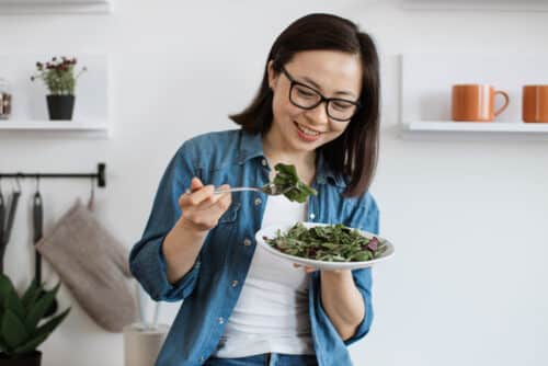 femme adulte mangeant une alimentation équilibrée dans un appartement moderne