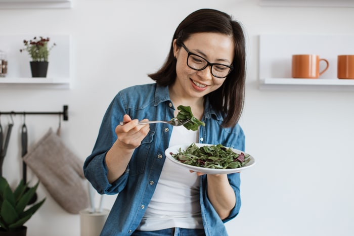 femme adulte mangeant une alimentation équilibrée dans un appartement moderne
