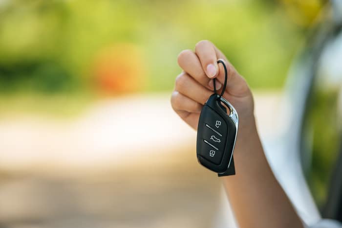 fille assise dans la voiture et tenant les clés de la voiture