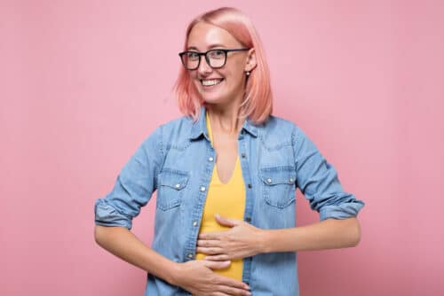 heureuse femme caucasienne n'ayant aucun problème de digestion tenant la main sur le ventre.heureuse femme caucasienne n'ayant aucun problème de digestion tenant la main sur le ventre.