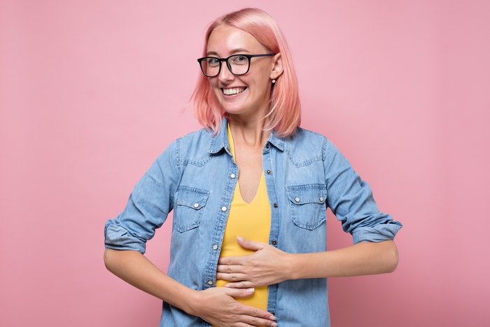 heureuse femme caucasienne n'ayant aucun problème de digestion tenant la main sur le ventre.heureuse femme caucasienne n'ayant aucun problème de digestion tenant la main sur le ventre.