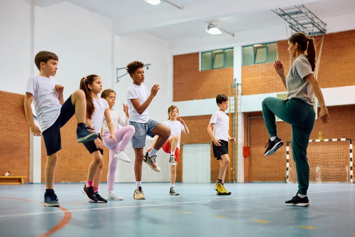 des écoliers et des professeurs de sport s'exerçant pendant les cours d'éducation physique au gymnase de l'école.