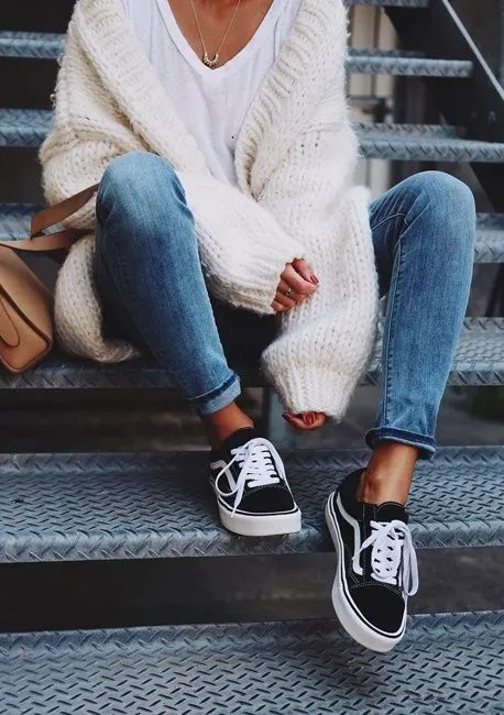 Jeune femme en tenue casual avec des Vans Old Skool noires et bande blanche latérale