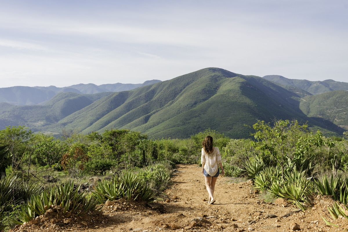 femme marchant le long d'un chemin de terre, vue arrière, hierve el agua, oaxaca, mexique.