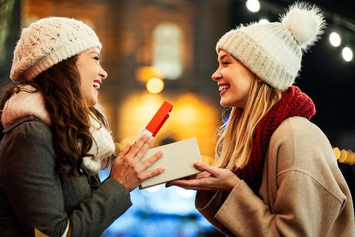 Deux amies heureuses échangeant des cadeaux de Noël 