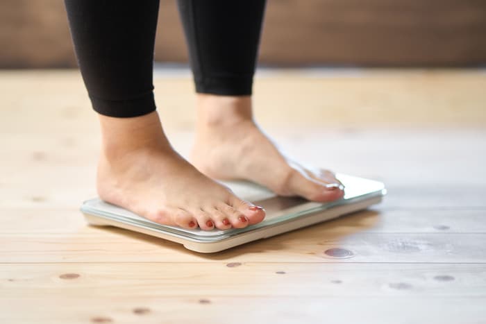Pieds d'une femme  sur une balance concept de prise de poids