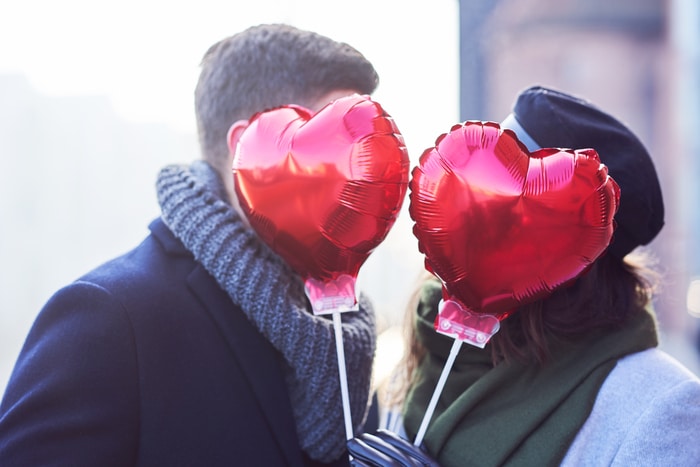 couple heureux célébrant la Saint Valentin avec des ballons en forme de coeur