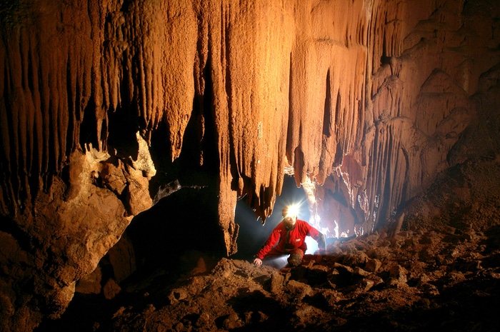 Femme explorant une grotte spéléologie vacances